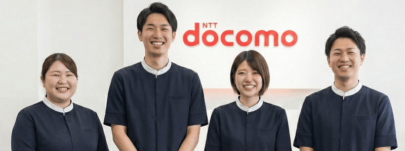 ドコモショップでスタッフが顧客にスマートフォンを案内する様子